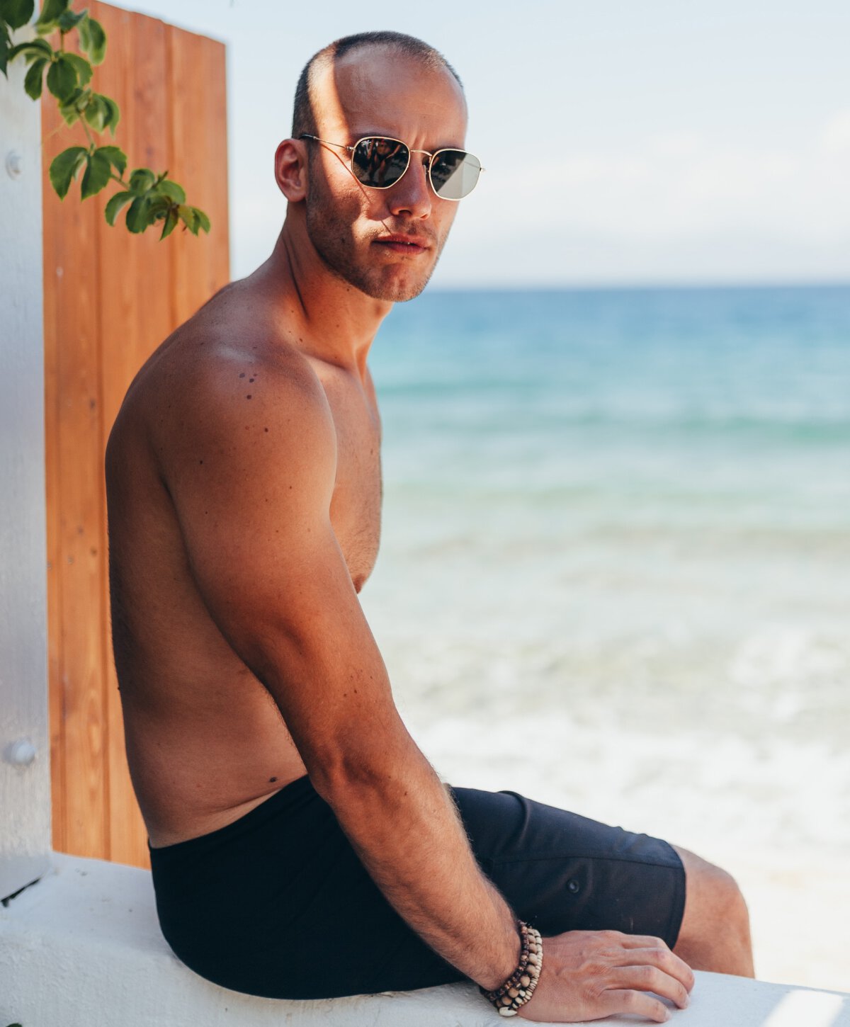 sarasota gynecomastia surgery model sitting by a beach